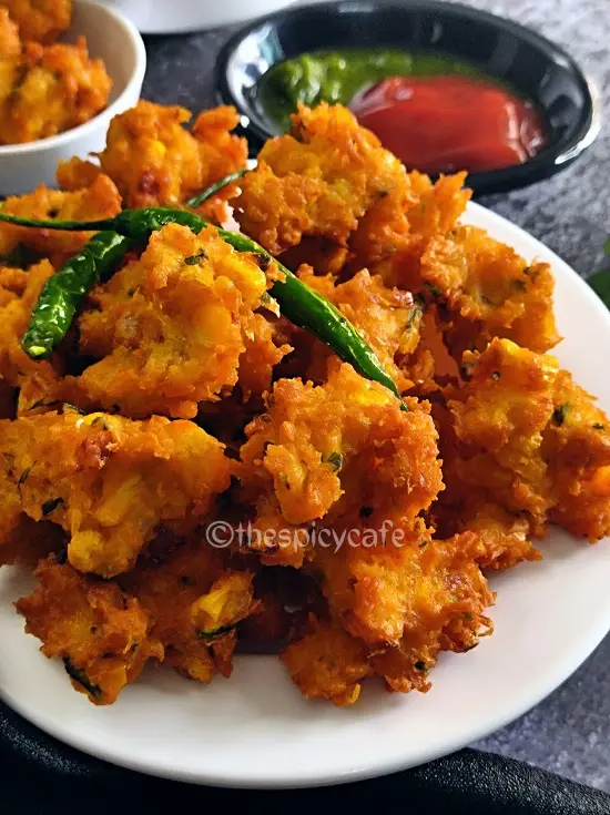 Corn Pakoda Recipe | Makai Bhajiya | Sweet Corn Fritters https://thespicycafe.com/wp-content/uploads/2023/08/2-sweet-corn-pakoda-crispy-corn-fritters-makai-bhajiya-vegan-vegetarian-Indian-street-food-snack-breakfast-lunch-dinner-easy-quick-simple-1.png https://thespicycafe.com/category/indian-snacks/